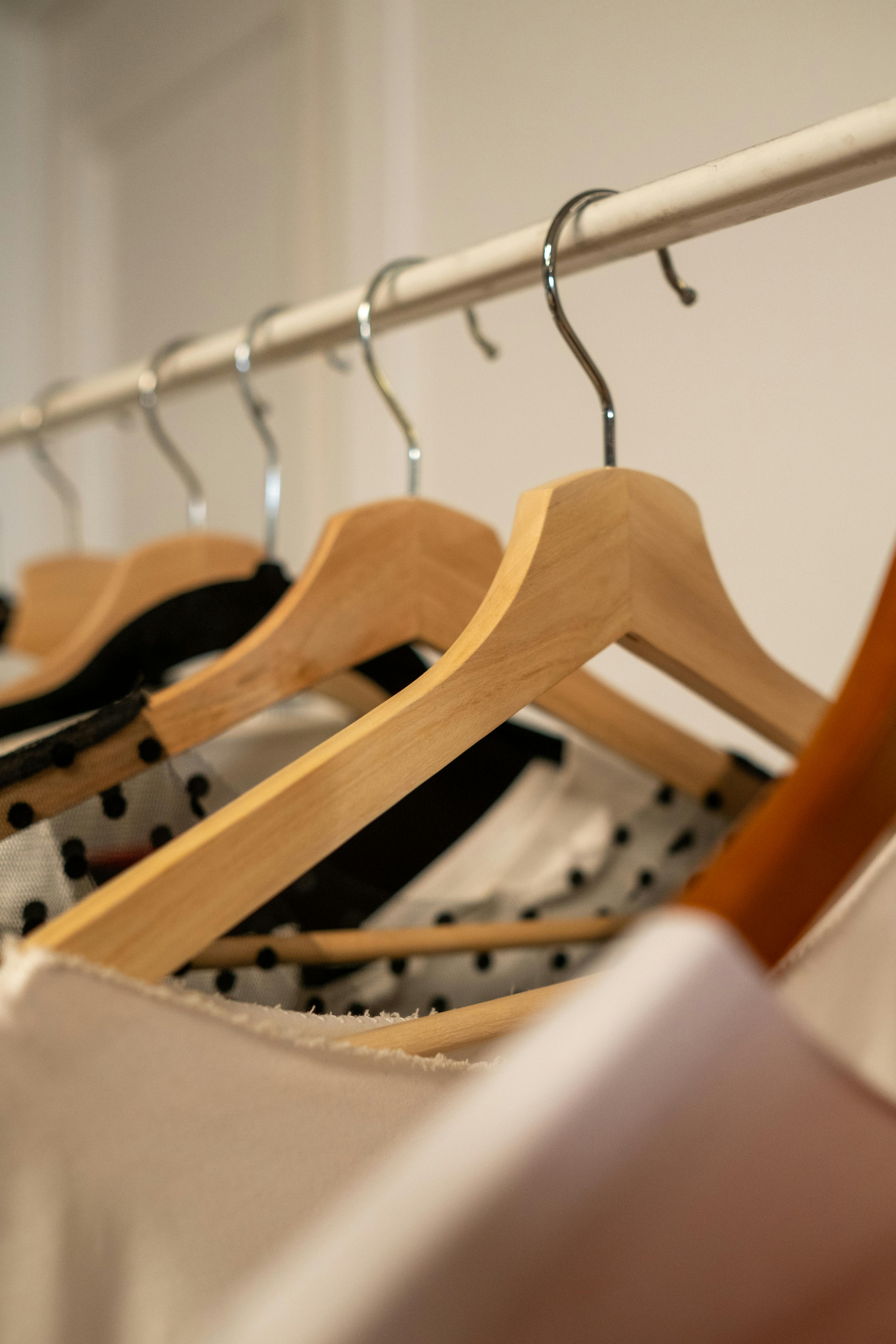 Wooden hangers on a clothes rail.